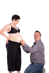 Papa misst den Umfang eines Babybauchs