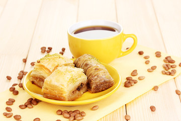 Sweet baklava on plate with tea on wooden background