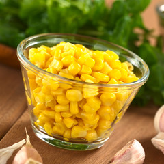 Sweetcorn grains in glass bowl with garlic and watercress