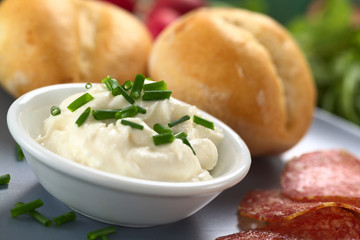 Cream cheese with chives, with salami and buns on plate