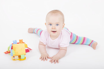 8 month old baby girl playing on the ground with her toy