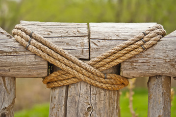 Two parts of a wooden fence tied together by the rope