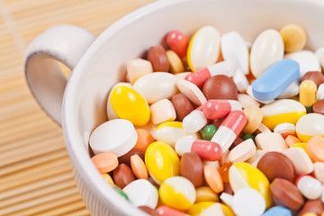 White cup filled with medicine pills and capsules