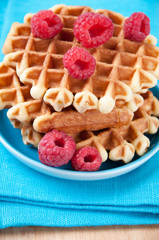 Close-up of a saucer with homemade waffles and raspberries