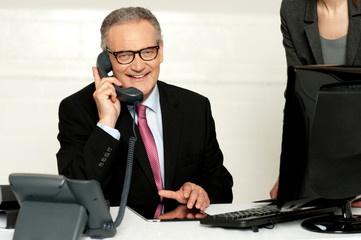 Aged businessman communicating on phone