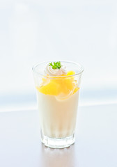 cup of orange panna cotta in white background