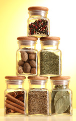 powder spices in glass jars on yellow background