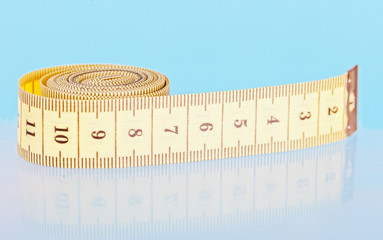Yellow measuring tapes on a blue background