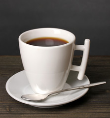 Coffee cup on wooden table on grey background
