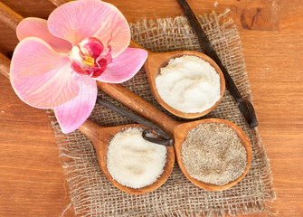 Obraz na płótnie Canvas Vanilla pods with vanilla and vanilla sugar in wooden spoons