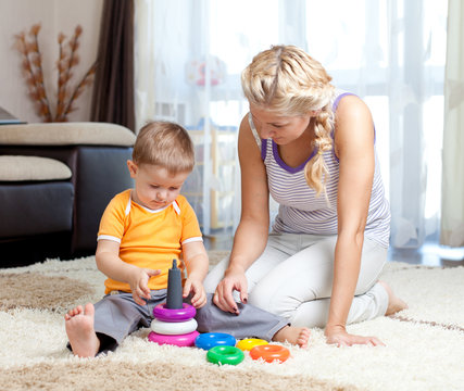 cute mother and kid boy playing together indoor