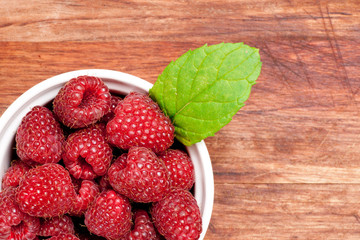 Bowl of raspberries on an old wooden table