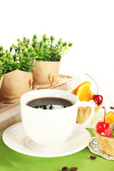 cup of coffee and sweet cakes with fruits on wooden table