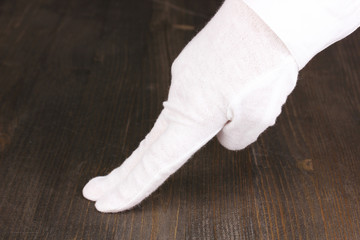 Female hand checking cleanliness on wooden background