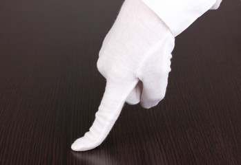 Female hand checking cleanliness on wooden background