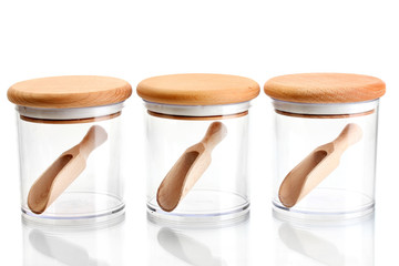 empty glass jars for spices with spoons isolated on white