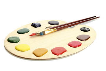 wooden art palette with  paint and brushes.isolated on white