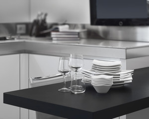 pila di piatti e bicchieri sul piano di lavoro in cucina moderna