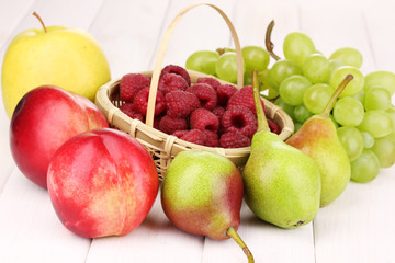 ripe sweet fruits and berries on wooden background