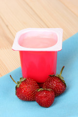 Yogurt with strawberry on wooden table