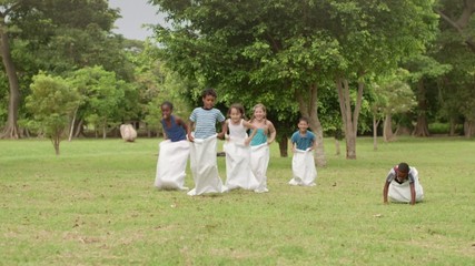 Elementary school children having fun and playing in park - Powered by Adobe