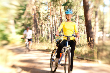 Fototapeta na wymiar Couple on bikes in the sunny forest