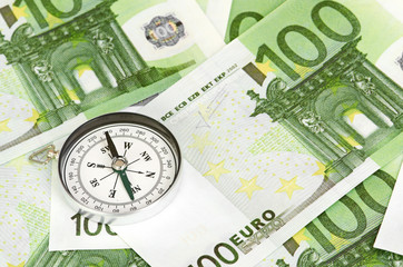 many euro bank notes and a compass