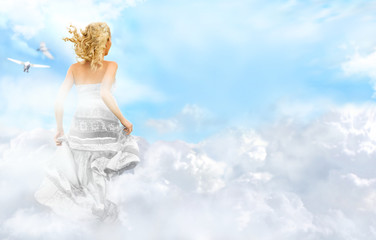 Young woman running across the clouds in the sky. Soul relaxatio