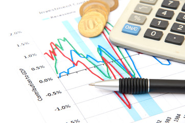 Calculator, coins and pen laying on chart