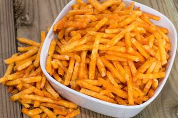 Potato Sticks in a bowl on wood