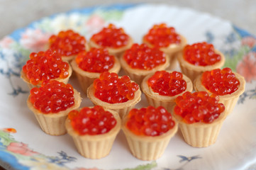Tartlets with red caviar on a plate