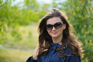 Woman in blue jacket in green summer park