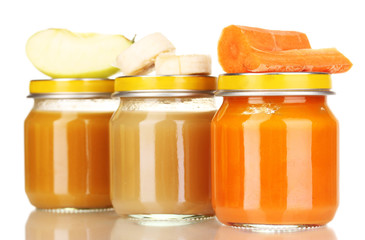 Jars of baby puree with spoon isolated on white