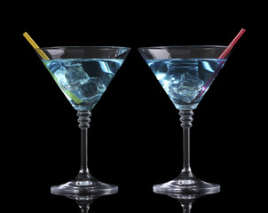 Blue cocktail in martini glasses isolated on black