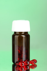 Jar of pills on green background close-up