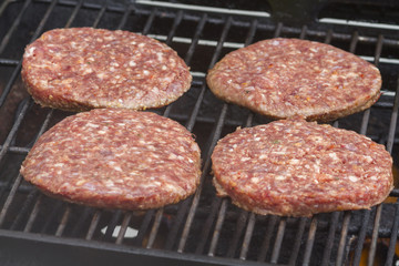 Raw  Burgers on a Barbecue