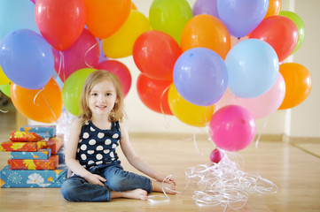Fototapeta na wymiar Little birthday girl with tons of balloons