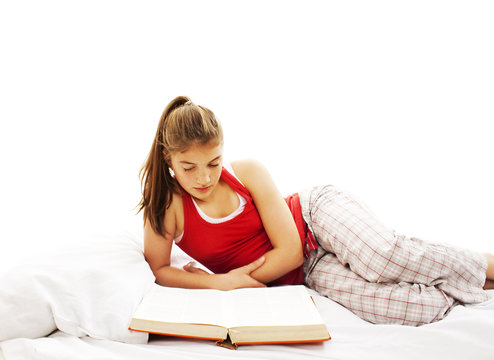 Young woman reading book in bed