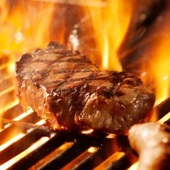 Printed kitchen splashbacks Grill / Barbecue beef steak on the grill with flames.