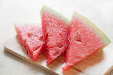 Three slices of watermelon on wooden board