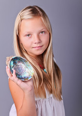 Young girl holding a seashell