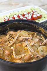 Scampi with potatoes in iron-cast pot