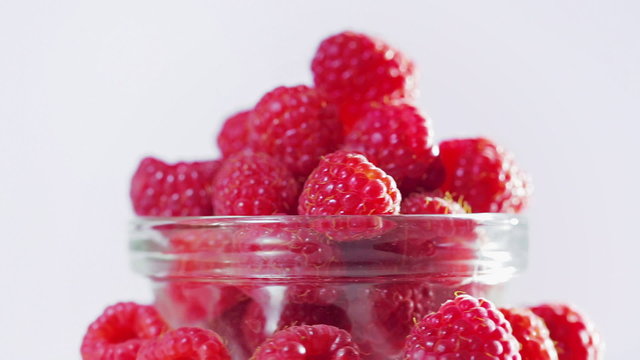 Raspberry fruit heap rotating on white background