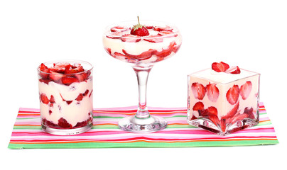 Glasses of ripe strawberries with cream isolated on white