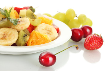 Fresh fruits salad on plate and berries isolated on white