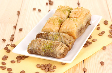Sweet baklava on plate on wooden background