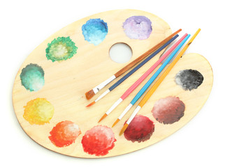 wooden art palette with paint and brushes isolated on white