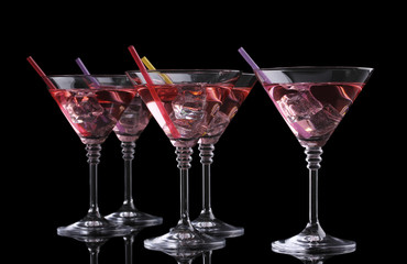 Red cocktail in martini glasses isolated on black