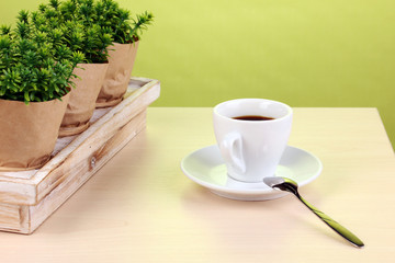Coffee cup on table in cafe on green background
