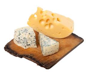 Various types of cheese on old wooden kitchen board